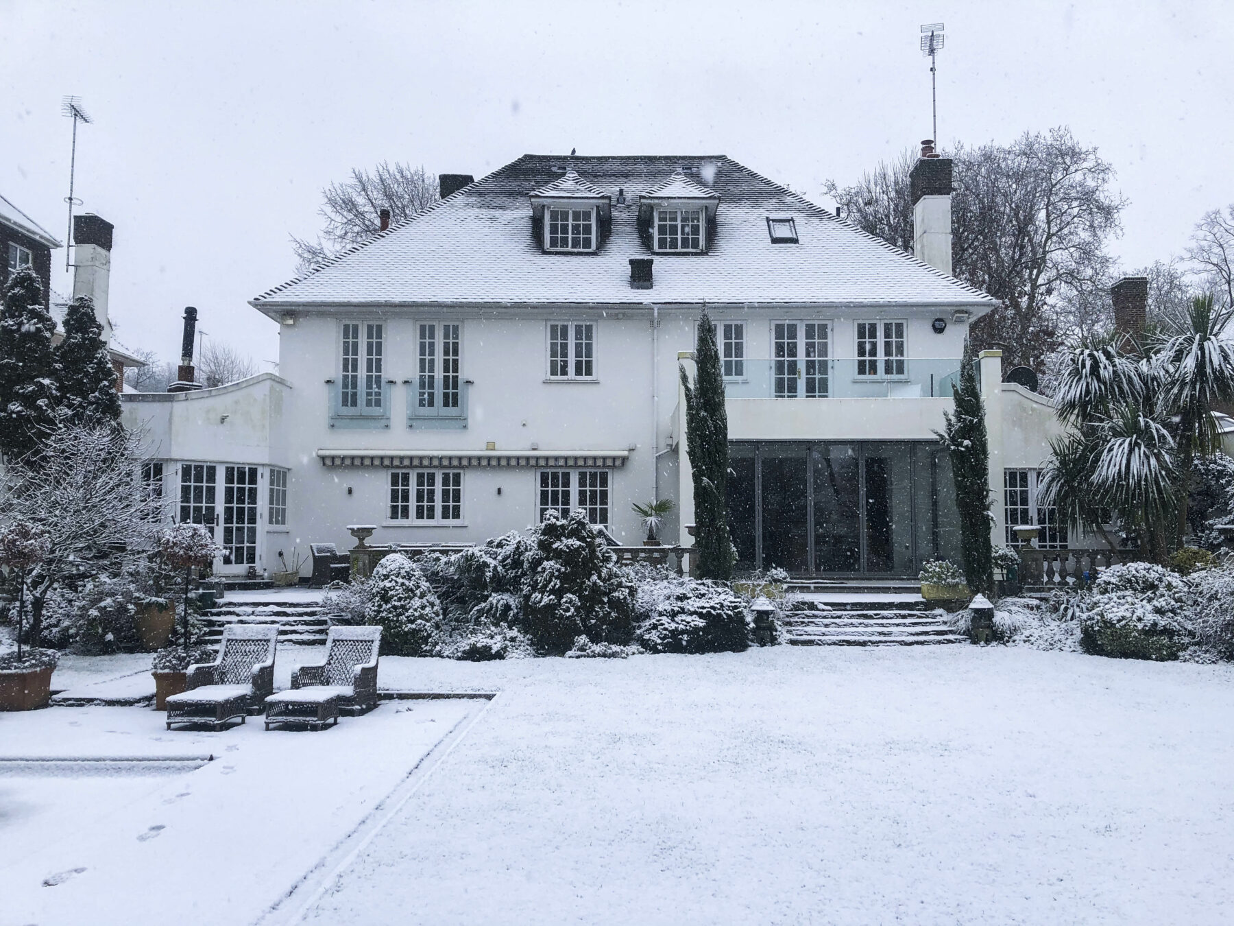 Rear garden white house art deco winter snow trees TV filming location hire lodge London 10